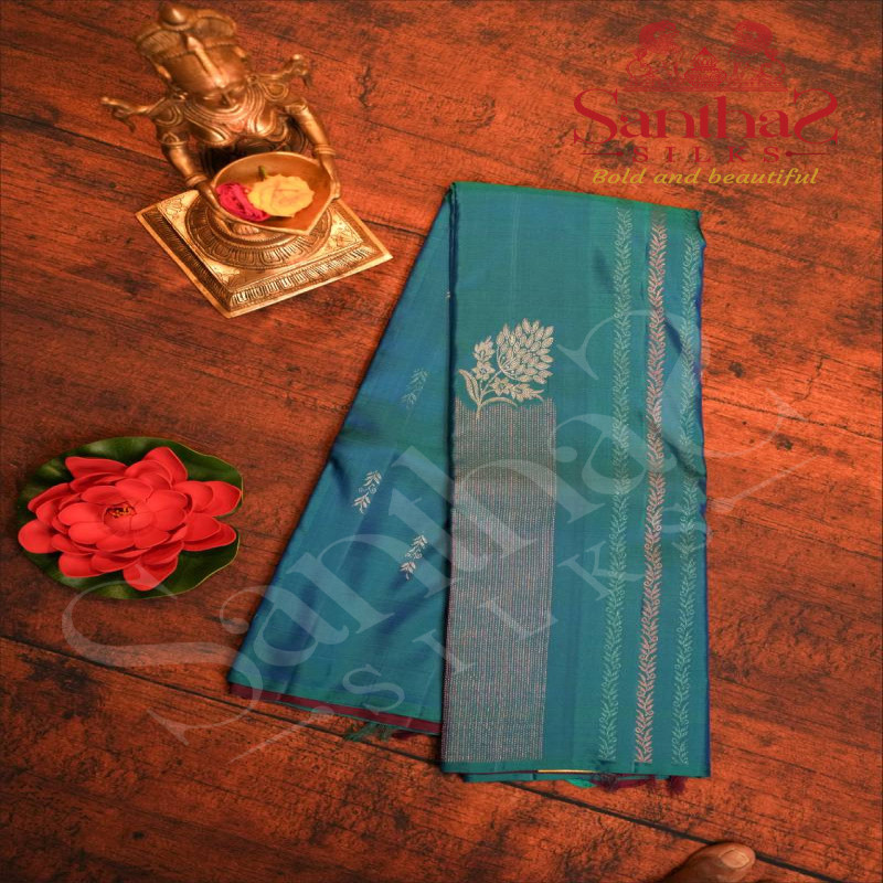 BORDERLESS PEACOCK BLUE COLOUR BODY WITH COPPER & BLUE ZARI KODI PATTERN & STRIPS AND CONTRAST BLOUSE